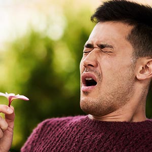 Older woman in field in discomfort rubbing between eyebrows with fingers